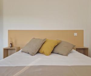 uma cama com duas almofadas em cima em Résidence Casamea, charmant T2 em Talasani