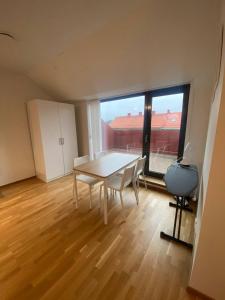une salle à manger avec une table et une grande fenêtre dans l'établissement Luxurious Flat With A Rooftop Terrace, à Göteborg