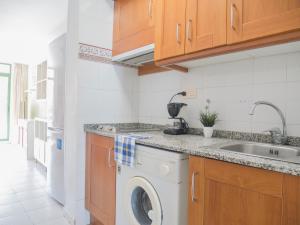 a kitchen with a washing machine and a sink at Apartamentos Sol Y Mar in Alcossebre