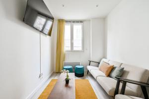 a living room with a couch and a tv at L'Edificio - Paris Disney - 5 chambres - 12p in Champs-sur-Marne