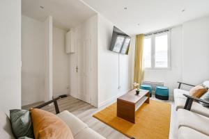 a living room with a couch and a table at L'Edificio - Paris Disney - 5 chambres - 12p in Champs-sur-Marne