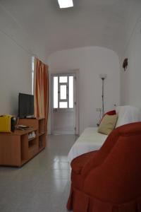 a bedroom with a bed and a couch and a television at Casa Almirante Reis in Olhão