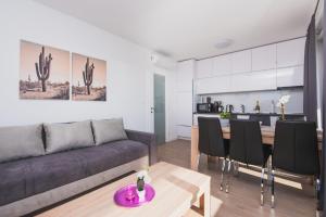 ein Wohnzimmer mit einem Sofa und einem Tisch in der Unterkunft Pool Apartments Villa Dalia in Novalja