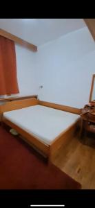 Bett in einem Zimmer mit einer weißen Matratze in der Unterkunft Big Apartments in Kopaonik