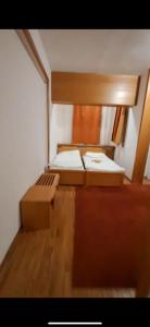 ein kleines Schlafzimmer mit 2 Betten und Holzboden in der Unterkunft Big Apartments in Kopaonik