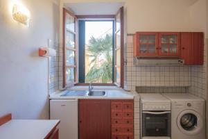 una piccola cucina con lavandino e finestra di Appartamento al Cotone - HelloElba a Marciana Marina