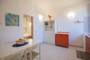 a kitchen with a table and a bowl of fruit on it at Appartamento al Cotone - HelloElba in Marciana Marina
