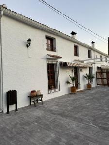 un edificio blanco con un banco delante en Cortijo Wenceslao II, 