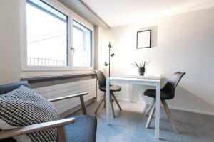 a room with a table and chairs and a window at Grubenmann Appartements - Sankt Gallen Town in St. Gallen