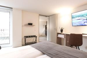 1 dormitorio con 1 cama y TV en la pared en Grubenmann Appartements - Sankt Gallen Town en St. Gallen