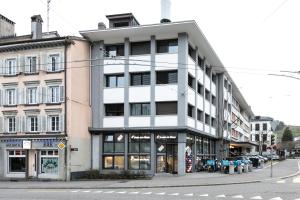 un edificio blanco alto en una calle de la ciudad en Grubenmann Appartements - Sankt Gallen Town, en St. Gallen