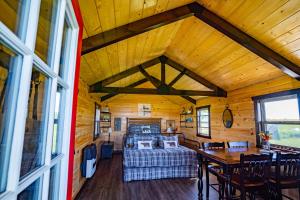 a room with a bed and a table in a cabin at Ravens Rest Retreat 