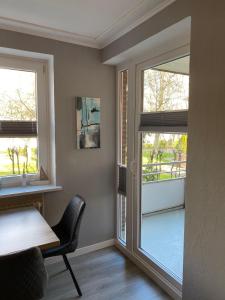 a dining room with a table and two windows at Ostseeapartment Allee Strandpark in Niendorf