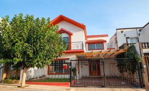 ein Haus mit einem Zaun und einem Baum in der Unterkunft Wide Family or for Business House in Chihuahua in Chihuahua