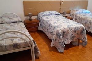 a bedroom with two beds and a wooden floor at Casa vacanza da Gina in Valeggio sul Mincio