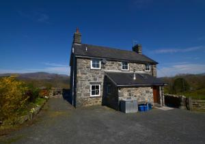 a stone house with a garage in front of it at Llwyniarth in Dolgellau