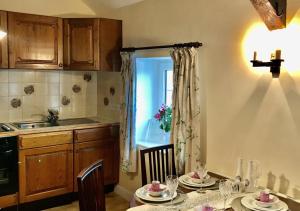 a kitchen with a table with chairs and a window at Granar y Garth in Aberystwyth