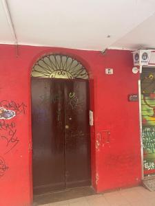 a red wall with a red door with graffiti on it at affittacamere bibiena nel cuore di bologna in Bologna