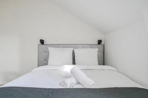 a white bed with two rolled towels on it at L'Edificio - Paris Disney - 5 chambres - 12p in Champs-sur-Marne