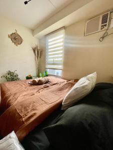 a large bed in a room with a window at Cabin in Urban - Urban Deca Homes - Manila in Manila