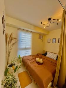 a bedroom with a large bed and a window at Cabin in Urban - Urban Deca Homes - Manila in Manila