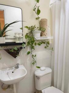a bathroom with a toilet and a sink and a mirror at Cabin in Urban - Urban Deca Homes - Manila in Manila