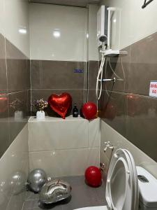 Gia Hân Hotel في مدينة هوشي منه: حمام مع مرحاض وقلب احمر على رف