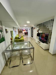 BADAROSA 2 House10min to BARCELONCity&NearTo BEACH في بادالونا: غرفة معيشة مع طاولة زجاجية وتلفزيون