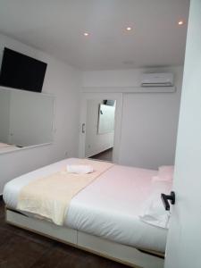 馬德里的住宿－Dreams Low Cost，卧室配有一张白色大床和镜子