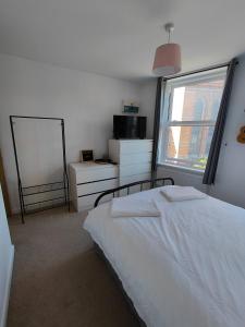 a bedroom with a white bed and a window at Central Caversham Reading one bed flat in Reading