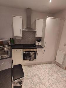 a kitchen with white cabinets and a stove at Central Caversham Reading one bed flat in Reading