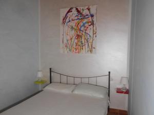sypialnia z łóżkiem i obrazem na ścianie w obiekcie Villacelest Casa Vacanze Peschici w mieście Peschici