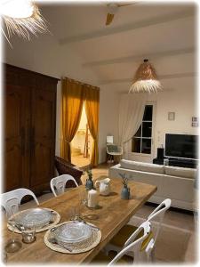 een woonkamer met een houten tafel en stoelen bij **** Les Petites Mares **** in La Mothe-Achard