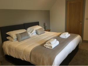 um quarto com uma cama grande e toalhas em Hunters Lodge em Barnstaple