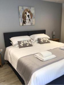 a bedroom with a bed with a dog painting on the wall at Hunters Lodge in Barnstaple