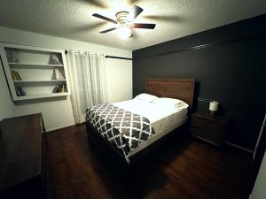 um quarto com uma cama e uma ventoinha de tecto em Super Cozy 4 Bedroom - Sleeps 10 Great for families and professionals em Katy