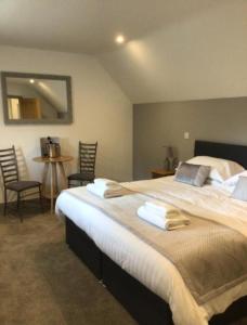 um quarto com uma cama grande e toalhas em Hunters Lodge em Barnstaple