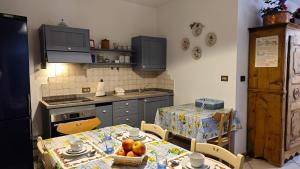 a kitchen with a table and a kitchen with a table and chairs at Hostdomus - La Posta apartment in Pragelato