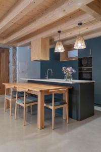 uma cozinha com uma mesa de madeira e algumas cadeiras em Casa Da Eira em Vila Real