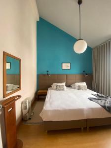 a bedroom with a large bed with a blue wall at Hospedaria Verdemar in Horta