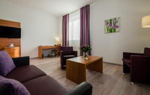 een woonkamer met een bank en een tafel bij Hotel Fortuna Reutlingen-Tübingen in Reutlingen