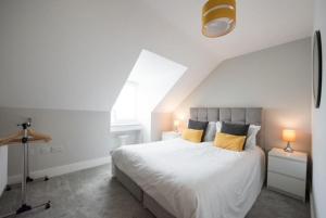 a bedroom with a large white bed with yellow pillows at Cosy, Bright, 1 Bed Flat in Brentwood