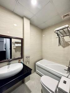 een badkamer met een wastafel, een bad en een toilet bij LION HOTEL in Can Tho