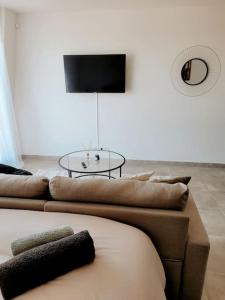 een woonkamer met 2 banken en een tafel bij Grand Studio Design 18 min Paris & Aéroport CDG in Le Blanc-Mesnil