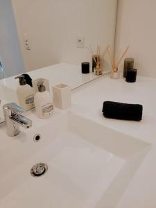 een wastafel met zeep en cosmetica bij Grand Studio Design 18 min Paris & Aéroport CDG in Le Blanc-Mesnil