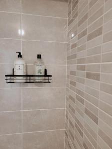 een badkamer met een douche en 2 flessen zeep bij Grand Studio Design 18 min Paris & Aéroport CDG in Le Blanc-Mesnil