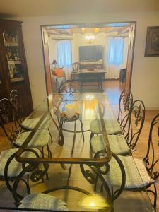 un soggiorno con tavolo e sedie in vetro di Casa Borgo Pietro a Galzignano