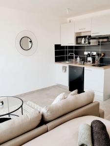 een woonkamer met een bank en een tafel bij Grand Studio Design 18 min Paris & Aéroport CDG in Le Blanc-Mesnil
