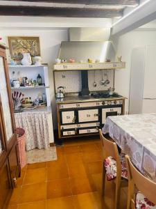 a kitchen with a stove and a table in a room at Casa Borgo Pietro in Galzignano