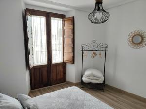 Schlafzimmer mit einem Bett und einer Holztür in der Unterkunft Apartamento rural "El Albarelo" in Belmonte